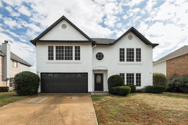 view of front of property featuring driveway, stucco siding, an attached garage, and a front yard