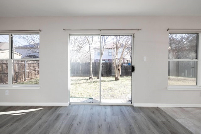 doorway to outside with wood finished floors and baseboards