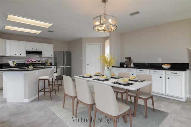 dining area with visible vents, arched walkways, and a chandelier