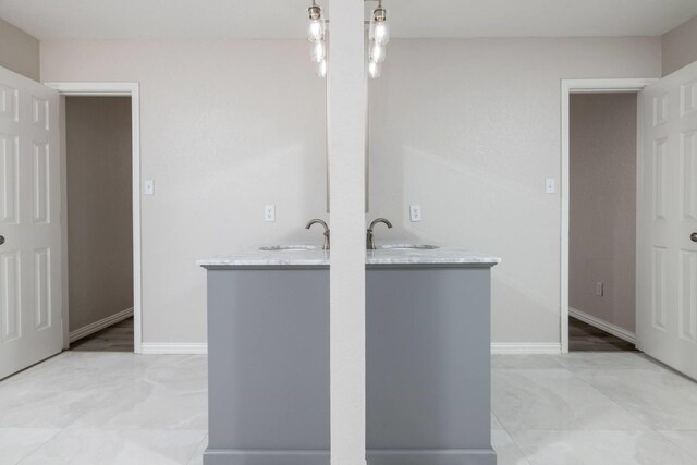 full bath featuring two vanities and baseboards