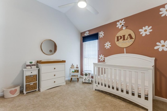 carpeted bedroom with lofted ceiling, a crib, and ceiling fan