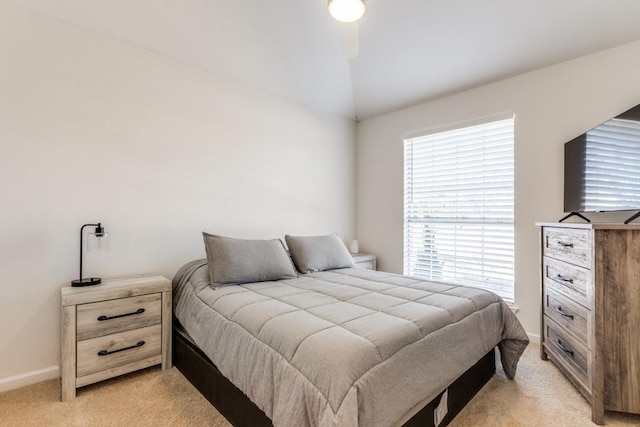 bedroom with lofted ceiling and light colored carpet