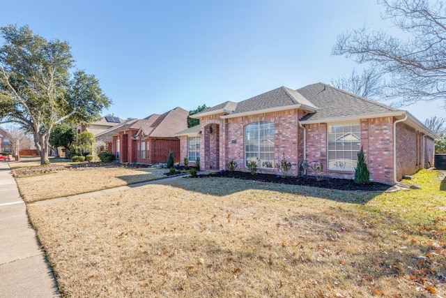 ranch-style home with cooling unit and a front lawn