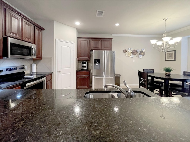4155 Nia Dr, Irving, TX 75038 - kitchen featuring appliances with stainless steel finishes, a sink, a chandelier, dark stone countertops, and crown molding