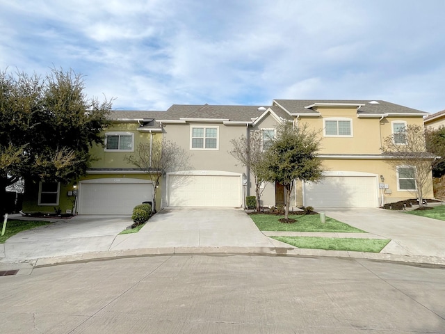 traditional-style house with concrete driveway, an attached garage, and stucco siding