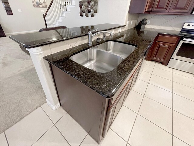 4155 Nia Dr, Irving, TX 75038 - kitchen with electric range, a sink, a peninsula, decorative backsplash, and dark stone counters