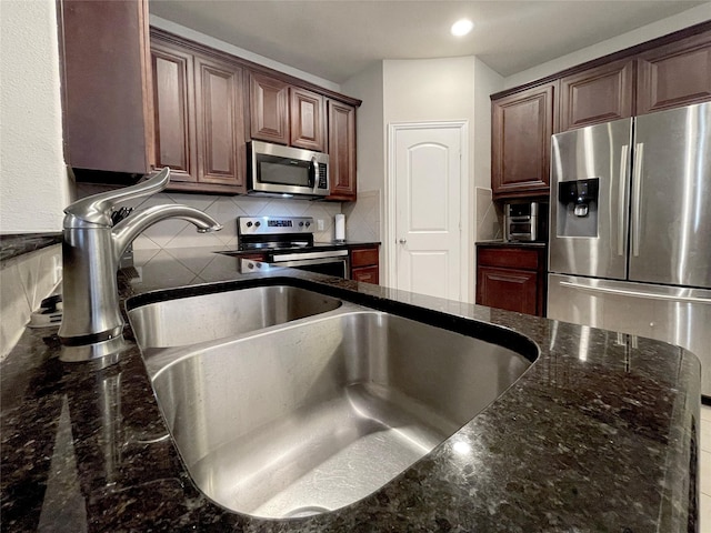 4155 Nia Dr, Irving, TX 75038 - kitchen with stainless steel appliances, backsplash, a sink, dark stone countertops, and recessed lighting