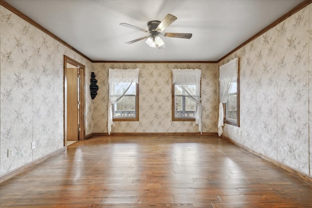 unfurnished room featuring crown molding, wood-type flooring, and ceiling fan