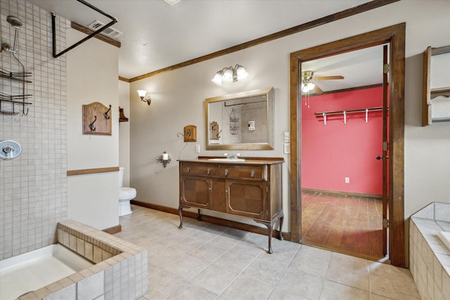 bathroom with crown molding, tile patterned flooring, vanity, a tile shower, and toilet