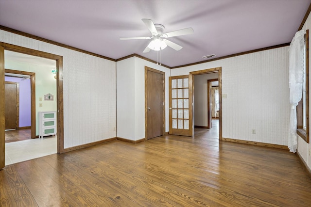 spare room with hardwood / wood-style floors, crown molding, and ceiling fan