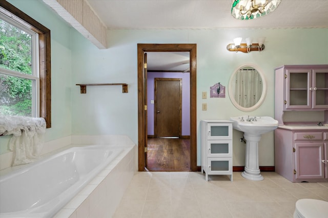 bathroom featuring a relaxing tiled tub and tile patterned floors