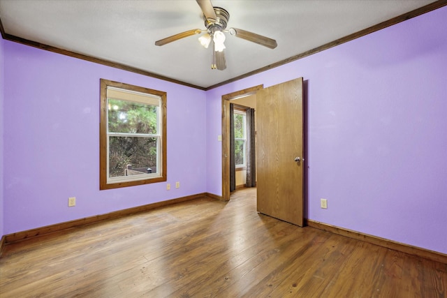 empty room featuring wood-type flooring, ornamental molding, and ceiling fan