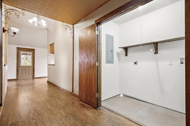 laundry room featuring light hardwood / wood-style flooring, electric dryer hookup, electric panel, washer hookup, and a notable chandelier