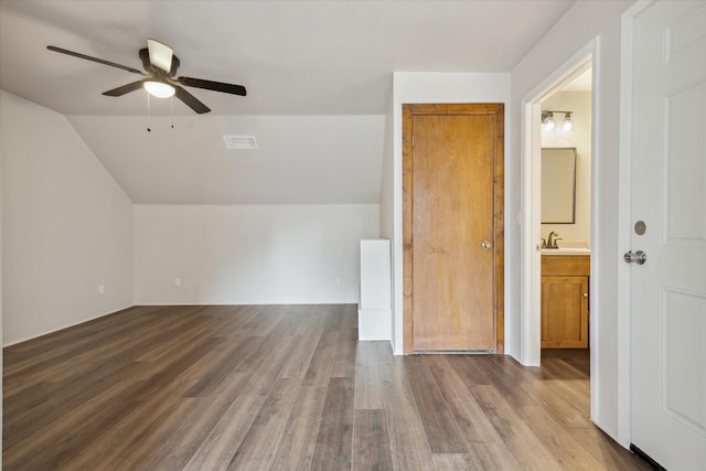 additional living space featuring lofted ceiling, sink, hardwood / wood-style flooring, and ceiling fan