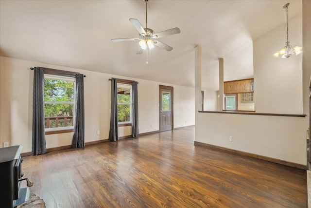 unfurnished living room with vaulted ceiling, dark hardwood / wood-style floors, and ceiling fan with notable chandelier