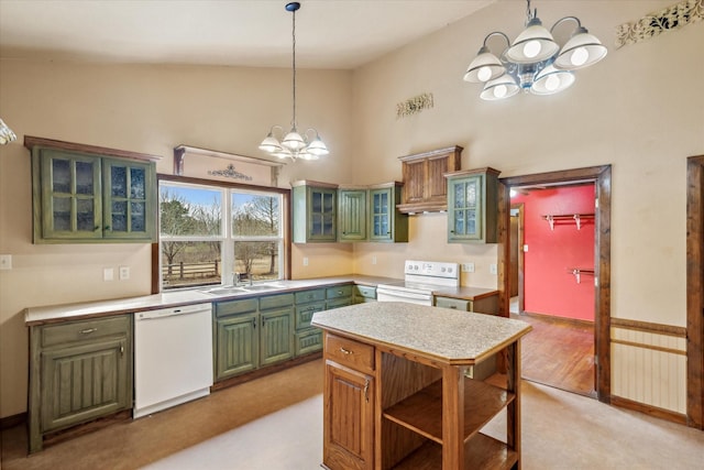 kitchen featuring sink, white appliances, hanging light fixtures, and a chandelier