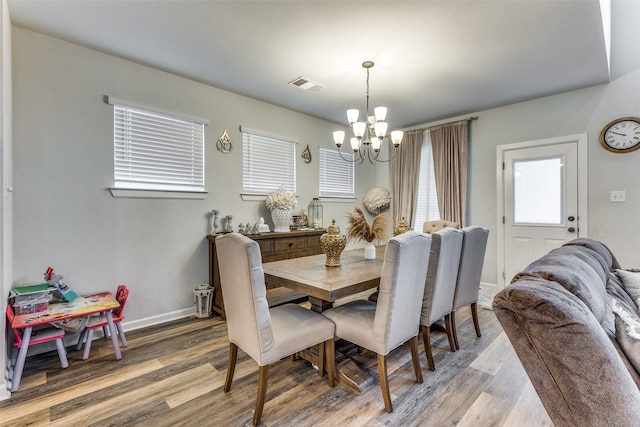 dining room with wood-type flooring and a chandelier