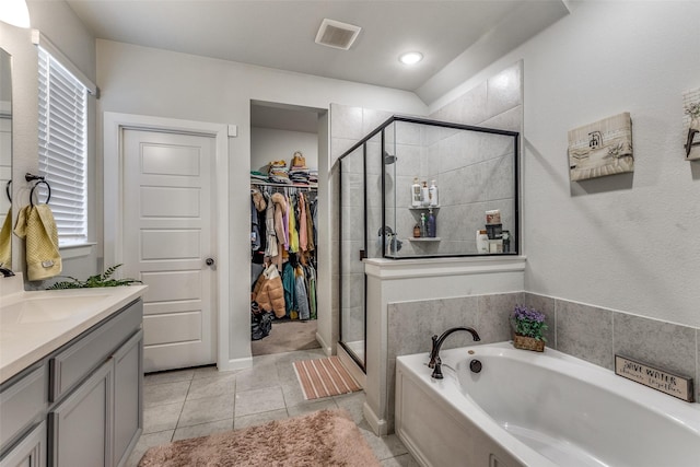 bathroom with tile patterned flooring, plus walk in shower, and vanity