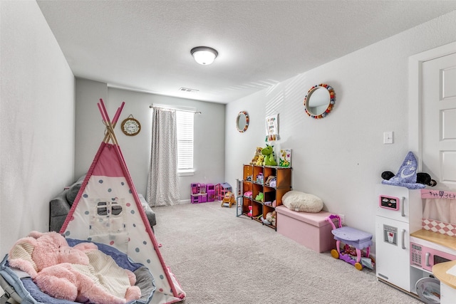 recreation room with carpet floors and a textured ceiling