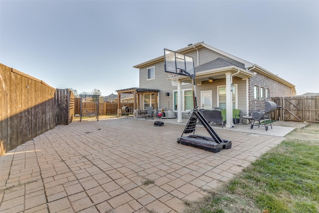 rear view of house featuring a pergola, a patio area, and ceiling fan