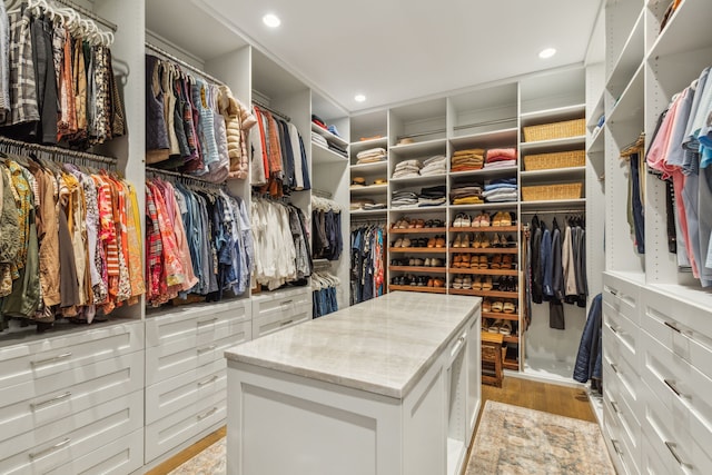 walk in closet with light hardwood / wood-style flooring