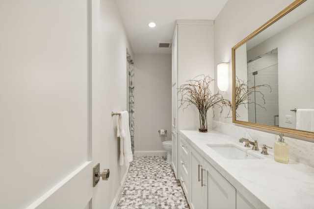 bathroom with vanity, a shower with shower door, and toilet