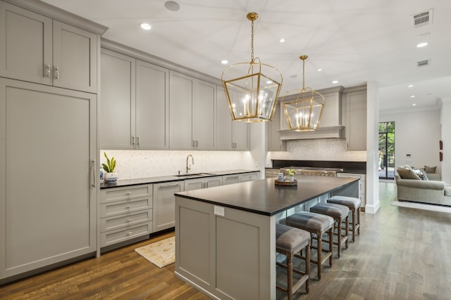 kitchen with sink, gray cabinetry, dark hardwood / wood-style flooring, pendant lighting, and decorative backsplash