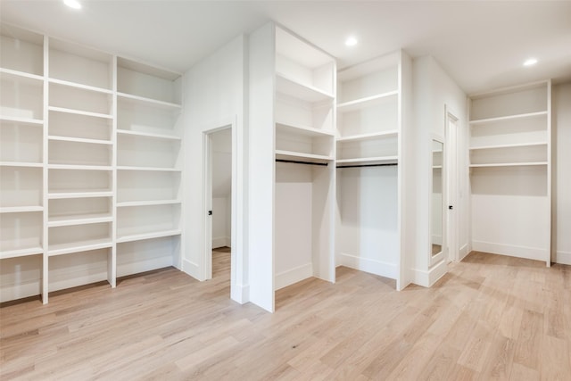 walk in closet with light hardwood / wood-style flooring