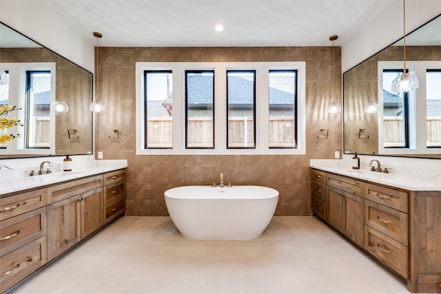 bathroom with tile walls, a bath, vanity, and tile patterned flooring