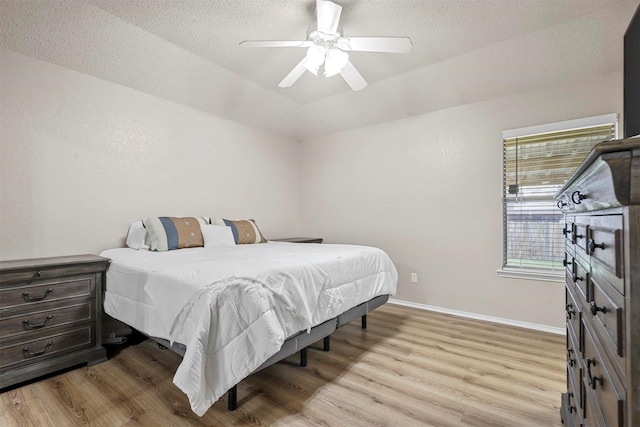 bedroom featuring a textured ceiling, light hardwood / wood-style floors, and ceiling fan