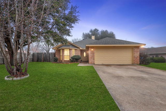 single story home featuring a garage and a lawn