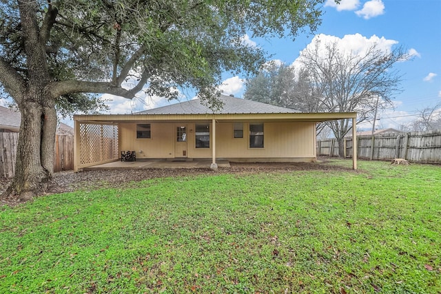 back of property with a yard and a patio