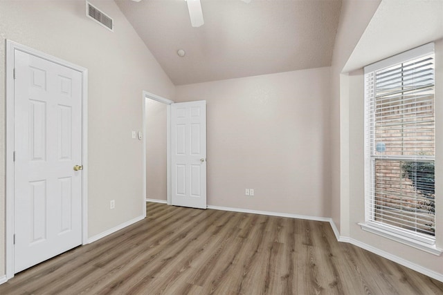 unfurnished bedroom with lofted ceiling, ceiling fan, and light hardwood / wood-style flooring