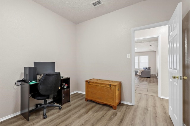 office space with light hardwood / wood-style flooring and a textured ceiling