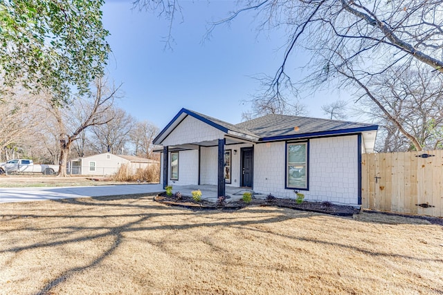 view of front of home featuring covered porch and a front lawn