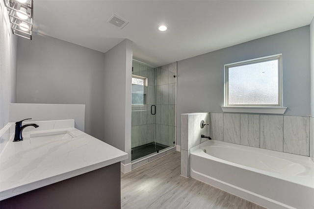 bathroom with hardwood / wood-style flooring, vanity, plenty of natural light, and shower with separate bathtub