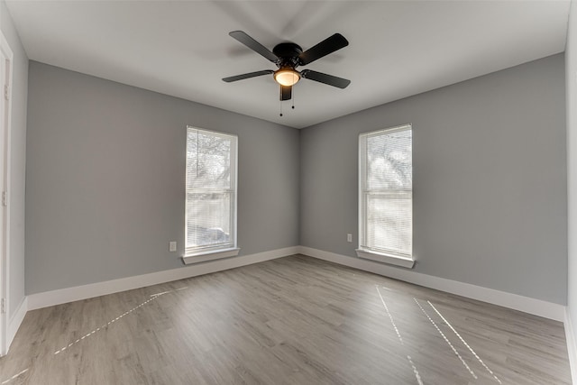 empty room featuring plenty of natural light, light hardwood / wood-style floors, and ceiling fan