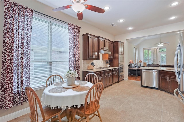 tiled dining room featuring ceiling fan and vaulted ceiling