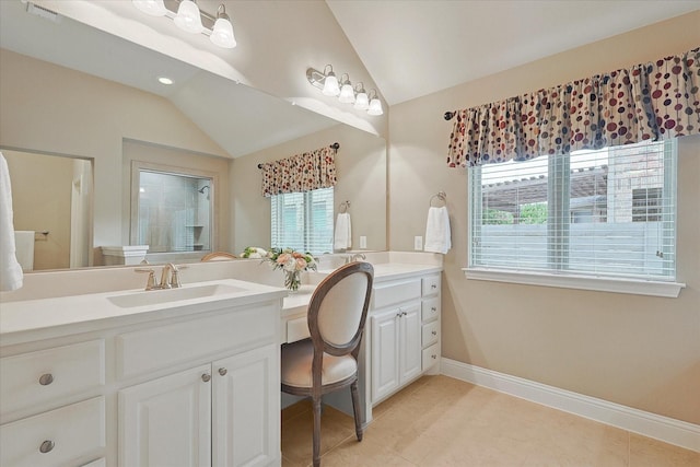 bathroom with vanity, vaulted ceiling, and tile patterned floors