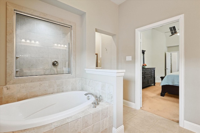 bathroom featuring a relaxing tiled tub and tile patterned flooring