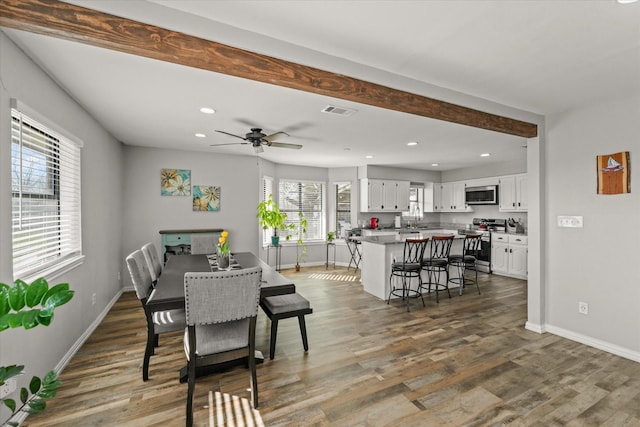 dining room featuring beam ceiling, ceiling fan, dark hardwood / wood-style floors, and sink