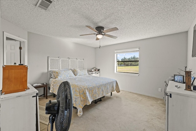 carpeted bedroom with ceiling fan and a textured ceiling