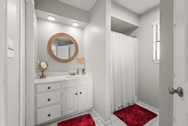 bathroom featuring a textured ceiling, vanity, and tile patterned flooring