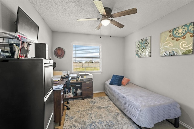 bedroom featuring ceiling fan and a textured ceiling