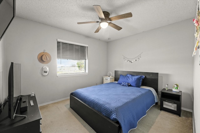 carpeted bedroom with ceiling fan and a textured ceiling