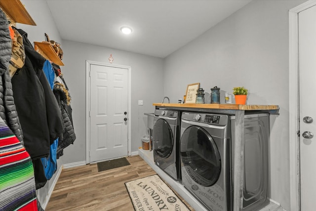 laundry room with hardwood / wood-style floors and washing machine and dryer