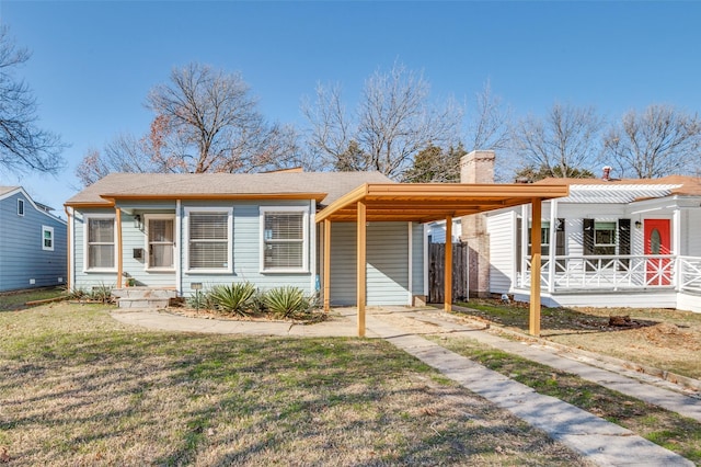 view of front facade with a carport, a porch, and a front lawn