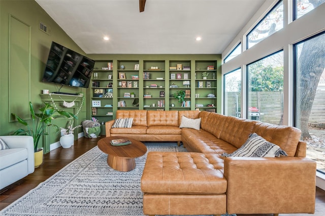 living room featuring dark hardwood / wood-style flooring, built in shelves, and vaulted ceiling