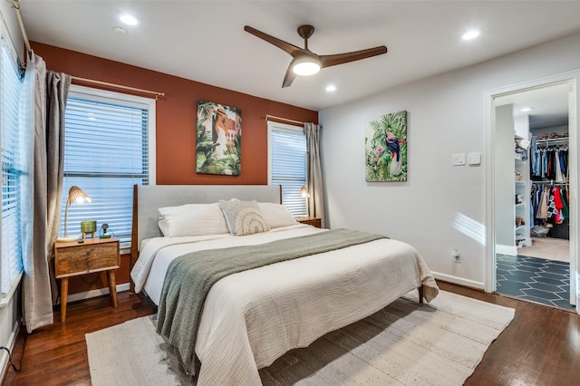 bedroom featuring ceiling fan, dark hardwood / wood-style floors, a closet, and a spacious closet