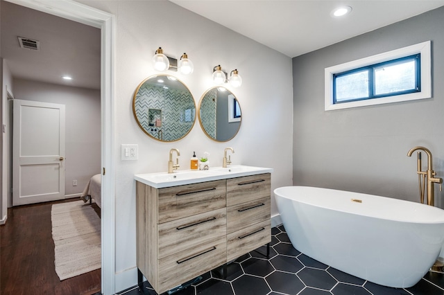 bathroom featuring tile patterned flooring, vanity, and a tub to relax in